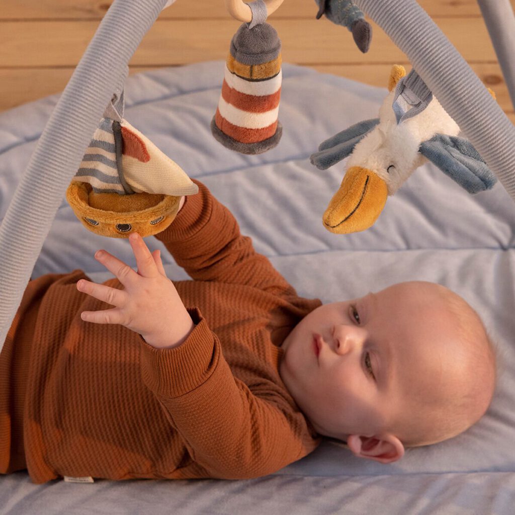 Kind ligt op speelkleed te spelen